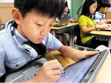 Students read textbooks on notebook PCs at Guil Elementary School in Seoul, South Korea. /Yonhap